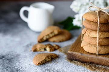 Homemade oatmeal cookies on a wooden cutting board on old table background