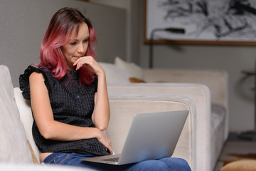 Portrait of beautiful businesswoman thinking while using laptop at home