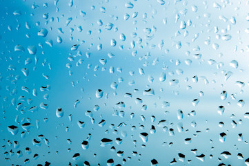 Realistic drops of falling water from the rain on a glass surface. Photo of transparent water bubbles on a window glass surface for your design.