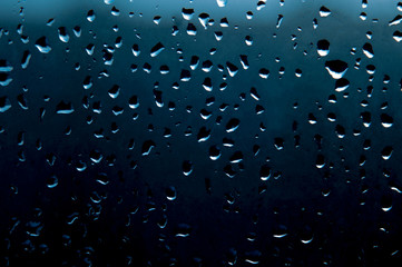 Realistic drops of falling water from the rain on a glass surface. Photo of transparent water bubbles on a window glass surface for your design.