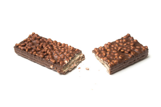 Closeup of broken chocolate bar with puffed rice on white background