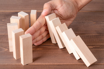 Man stopping domino effect. Risk control, solution to problem, insurance, business strategy concept