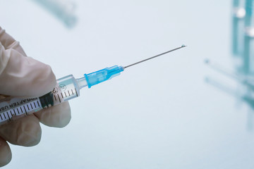 Doctor holding a syringe with a transparent injection. Close-up.