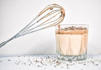 Milkshake kawowo-czekoladowy w szklance na białym tle