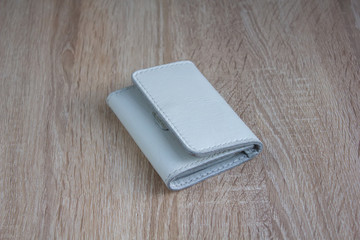 White leather wallet on a wooden tableWhite handmade leather wallet on a light wooden table
