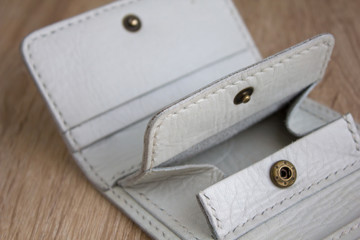 details close up of a white handmade leather wallet on a light wooden table