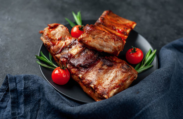 Grilled pork ribs with spices on a plate on a stone background