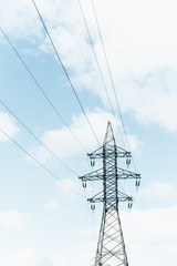 high-voltage tower with wires against the blue sky. vertical photo