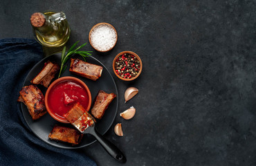 
Grilled pork ribs with spices on a plate on a stone background 
with copy space for your text