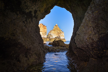Natural archway through which you can see the sea. Uncrowded travel concept. Algarve, Portugal. Algarve, Portugal