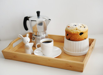 Coffee and cupcake served in wooden bamboo tray. Coffee maker moka pot, white dishes.