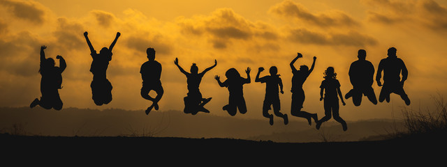 The black silhouette of a large group of people jumping together with joy On the occasion of the celebration of the team's success The atmosphere of the sunset means success in work.