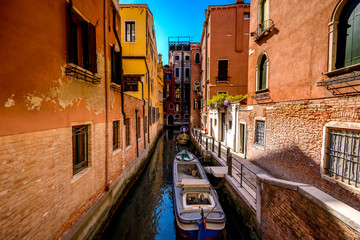 Fototapeta na wymiar Anchored boats on a canal in Venice