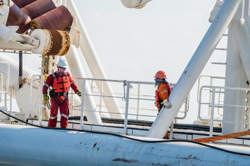 Riggers preparing sling on a derrick lay barge's stinger after its intallation during mobilization...