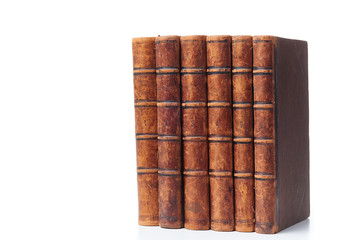 A stack of old books bound in brown leather, isolated on a white background. Space for text
