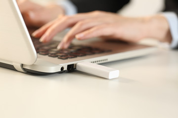 Executive hands typing on laptop with pendrive connected