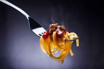 Pasta with sauce and ground meat mounted on the fork