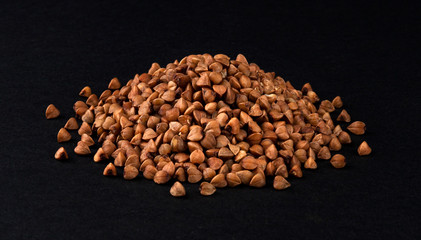 Heap of buckwheat isolated on black background