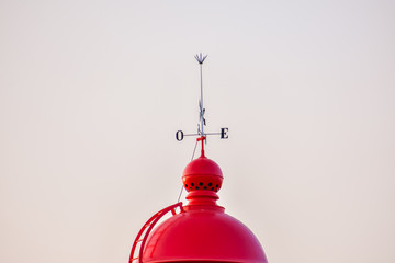 Red dome of the Ponta da Piedade lighthouse, with a wind vane on top. Algarve, Portugal
