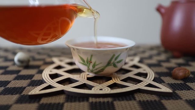 Chinese puer tea is poured closeup in a small cup