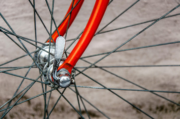 Bicycle repair. Wheel and shiny axle of chrome steel of an old road bike closeup. Retro bike. Red iron fork. Quick Release.