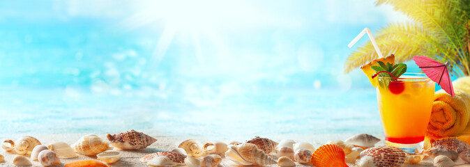 Beautiful sand beach background with summer drink and seashells on the seashore. Copy space for text.