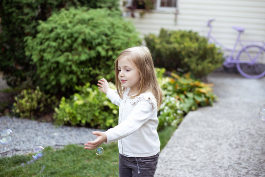 little girl play with bubbles in nature
