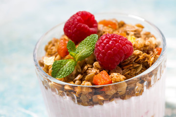 sweet dessert with granola, raspberry and fruit yoghurt, closeup