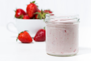 sweet strawberry yogurt and fresh berries on a white background, closeup