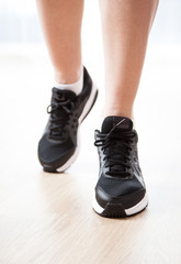 Female legs wearing in black sneakers