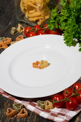 table setting with pasta and vegetables on wooden background, closeup
