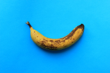 overripe ugly banana on a colored background