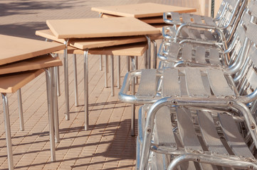Metal chairs stacked next to outdoor tables