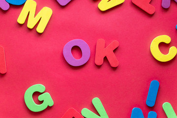 Word OK From Plastic Magnetic Letters On Red Background