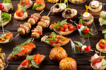 Set of different food snacks and appetizers on wooden background. Beautiful catering banquet buffet table.