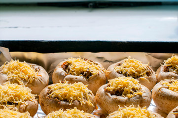 mushrooms with grated cheese before baking in the oven