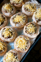 mushrooms with grated cheese before baking in the oven