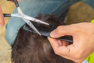 Father cutting son's hair at home during confinement by covid-19