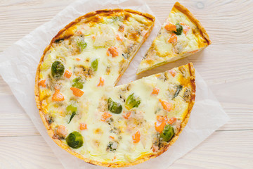 smoked salmon, Brussels sprouts and gorgonzola quiche tart, top view. Piece of homemade pie
