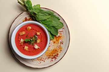 Homemade tomato soup with bread, mint and olive oil