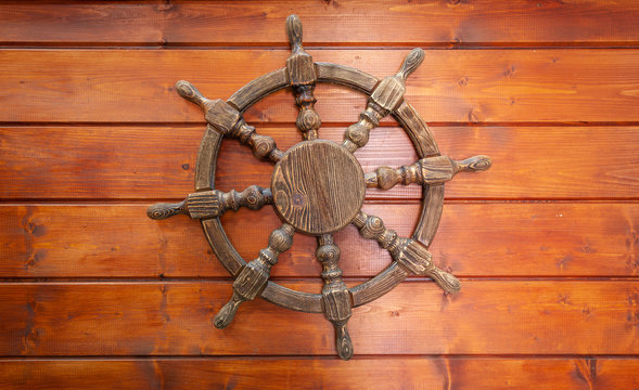 The background of the sea characters. Steering wheel of the ship on a wooden Board