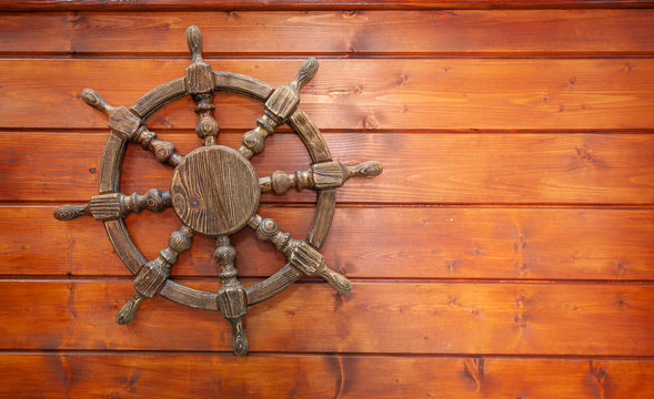 The background of the sea characters. Steering wheel of the ship on a wooden Board