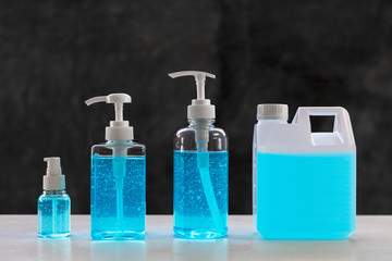 Blue alcohols gel on white table and  calcium oxide background. Hand sanitizer gel for clean. Hand sanitizer in 3 different size dump bottle. and 1L. bottle.