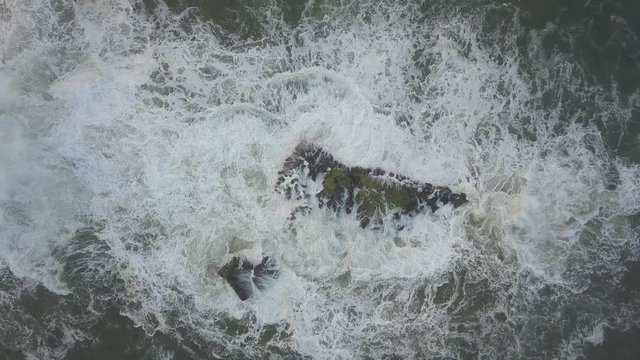 Waves crash against the rocks. An iconic place on the Atlantic coast, the Mecca of surfing on big waves.Rocks at the Nazare Lighthouse, the place with the largest waves in Europe, Nazare, Portugal.