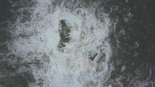 Waves crash against the rocks. An iconic place on the Atlantic coast, the Mecca of surfing on big waves.Rocks at the Nazare Lighthouse, the place with the largest waves in Europe, Nazare, Portugal.