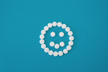 Pills positive smile on blue background, smile is centered , concept mood, isolated