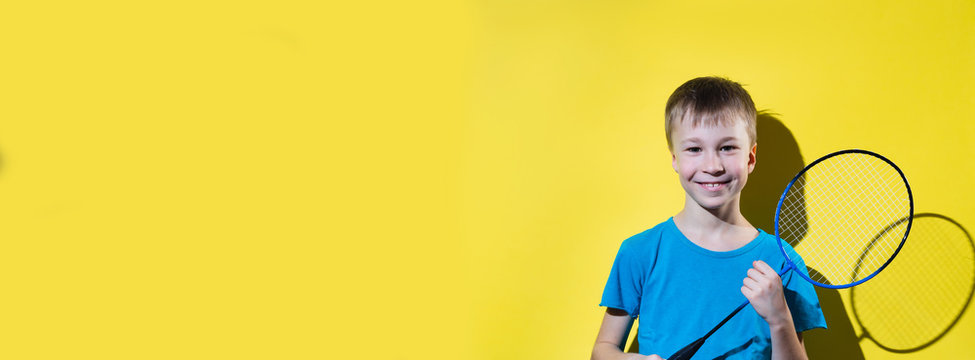 Happy child with badminton racket isolated on yellow background. Banner edition.