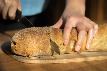 Woman Slicing A White Baguette, Hands Only