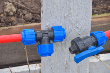 irrigation hose is attached to the fence on the garden plot
