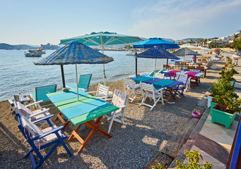 Cute chairs and table on the beach at seaside restaurant in Bodrum